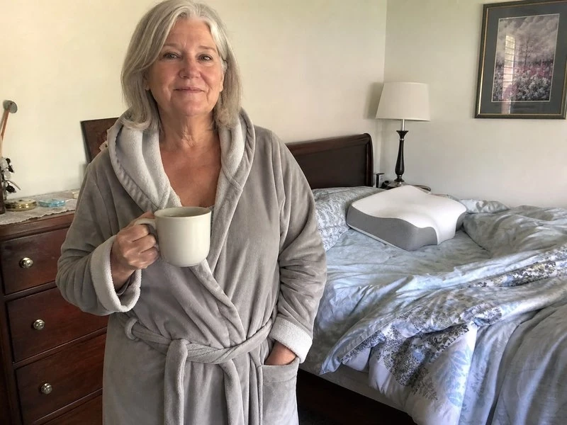 Linda, 61, having coffee in her bedroom in the morning